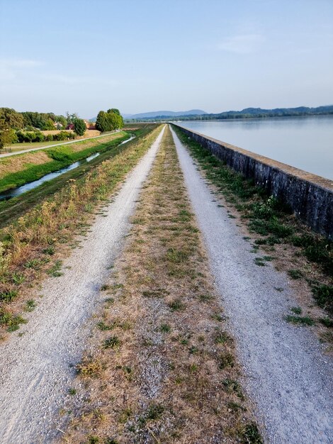 Foto de weg midden in het veld tegen de lucht.