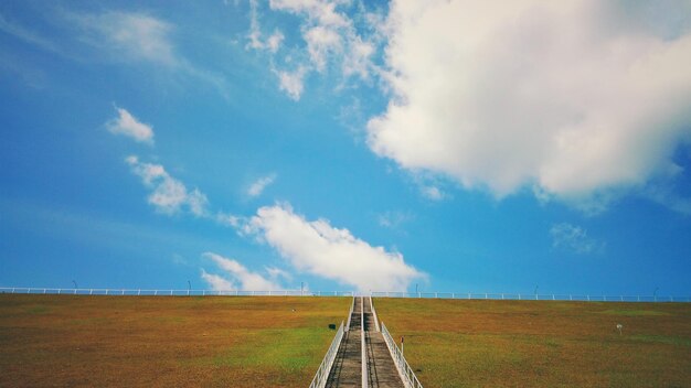 Foto de weg midden in het veld tegen de lucht.