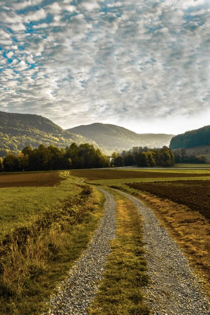 Foto de weg midden in het veld tegen de lucht.