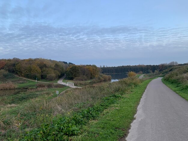 Foto de weg midden in het veld tegen de lucht.