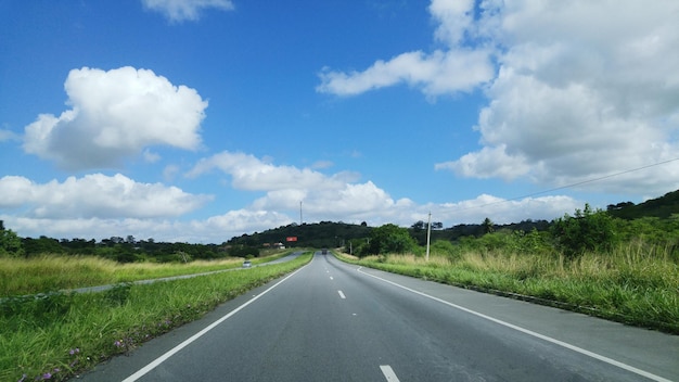 De weg midden in het veld tegen de lucht.