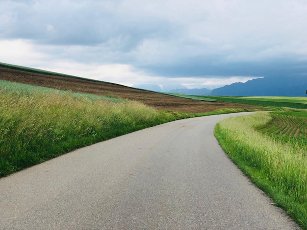 De weg midden in het veld tegen de lucht.