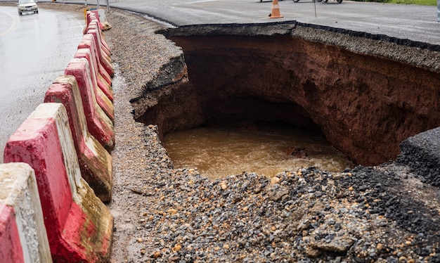 De weg werd verwoest door watererosie veroorzaakt door hevige regenval en overstromingen van de weg.