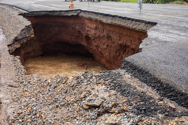 De weg werd verwoest door watererosie veroorzaakt door hevige regenval en overstromingen van de weg.