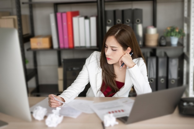 De werkende vrouw in witte pak denkt aan nieuw project.