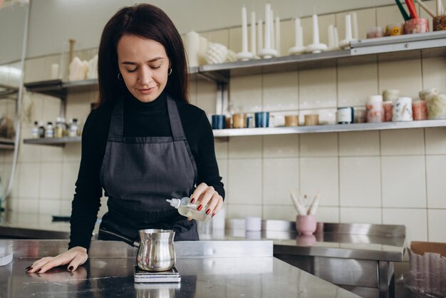 De werkplek van een mooie jonge vrouw houdt zich bezig met de productie van aromatische waskaarsen in de vorm van een vrouwelijk Venus-lichaam