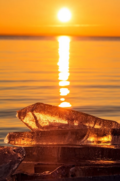 De winterzonsondergang met blok van ijs