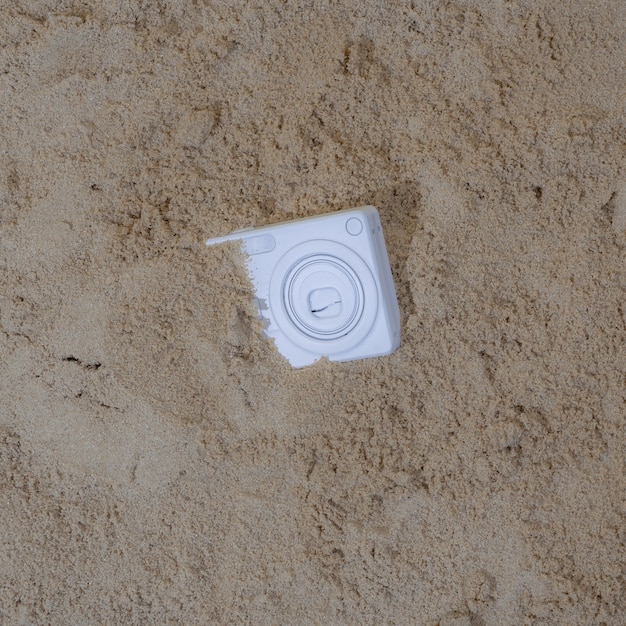 De witte camera werd begraven in het zand van de vakantie