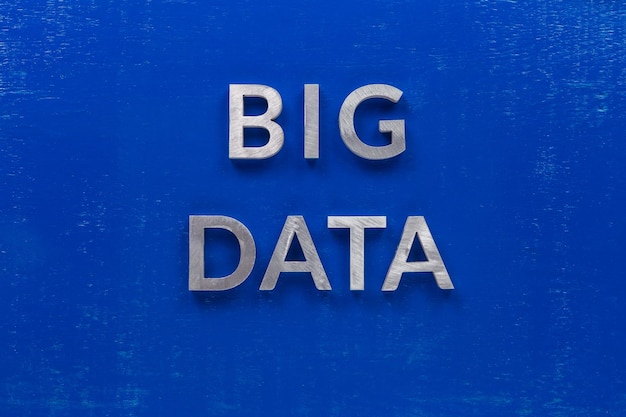 De woorden big data gelegd met zilveren metalen karakters op blauw geschilderd houten bord in centrale platliggende compositie
