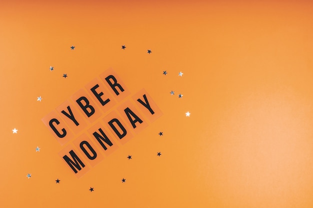 Foto de woorden cyber monday op een fel oranje achtergrond met lovertjes. plat leggen, ruimte kopiëren