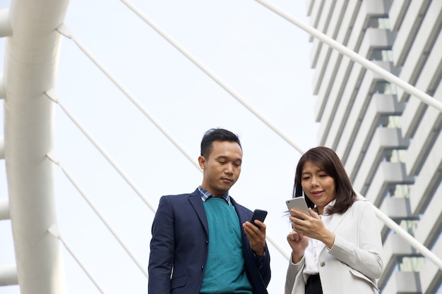 De zakenman en de vrouw controleren beurs van mobiele telefoon