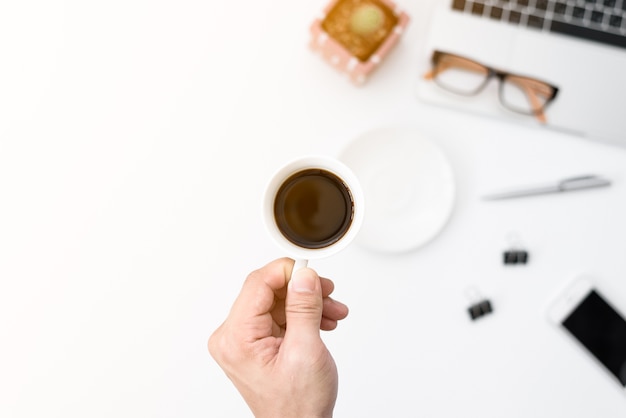 De zakenman heeft het houden van zwarte koffiekop aan het drinken bij het harde werken in de ochtend.