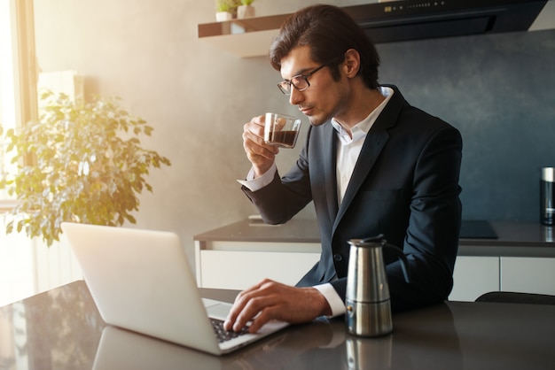 De zakenman werkt van ver bij huis met laptop