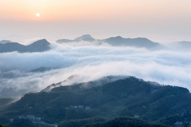 De zee van wolken op bergdorp in zonsopgang China