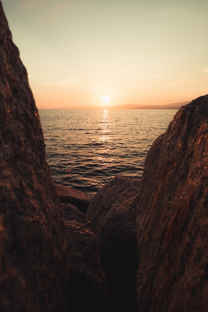 De zee vanaf de rotsen tijdens een zonsondergang