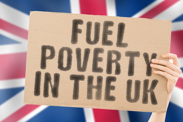 De zinsnede "brandstofarmoede in het VK" op een spandoek in de hand van mannen met de vage Britse vlag op de achtergrond. Economisch. Duur. Depressief. Benzine. Fossiel. Probleem. Leveren. Maatschappelijke kwesties