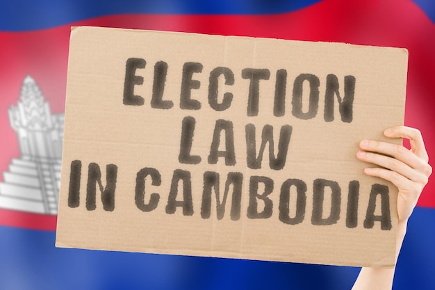 De zinsnede kieswet in Cambodja op een spandoek in mannenhanden met een vage Cambodjaanse vlag op de achtergrond Grondwet Politieke Senaat Phnom Penh Electoraat meerderheid