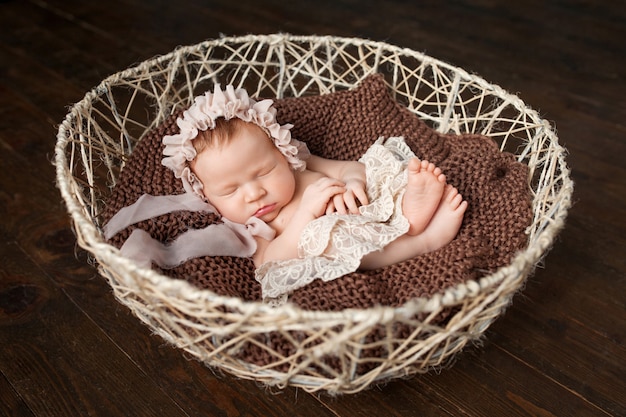 De zoete pasgeboren slaap van het babymeisje in de mand.