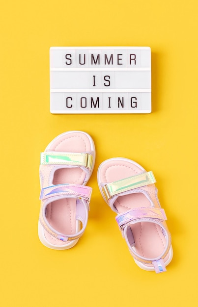 De zomer komt eraan Motiverende citaat op lightbox en stijlvolle holografische sandalen op gele achtergrond Bovenaanzicht Plat lag Creatief inspirerend zomerconcept