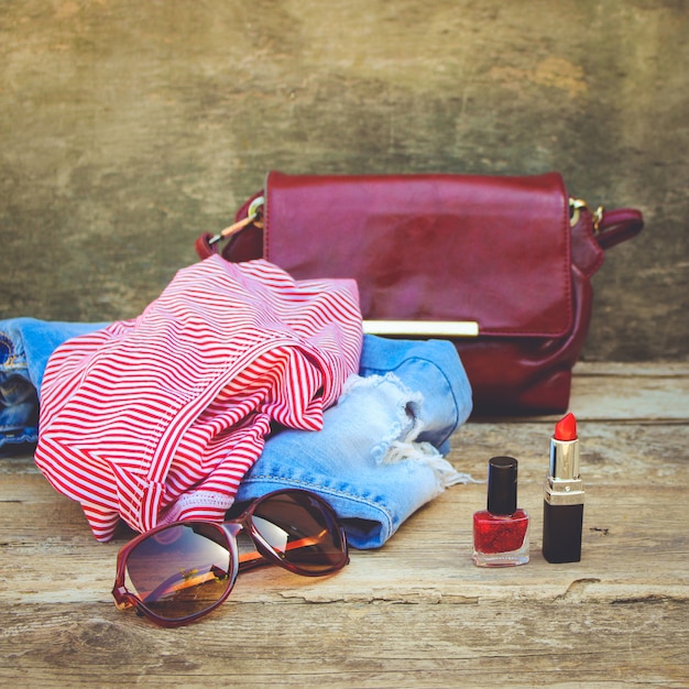 De zomerkleding en schoonheidsmiddelen van vrouwen op oude houten achtergrond