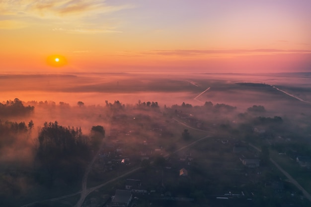 De zomerzonsopgang in de gebieden en het bos met mist