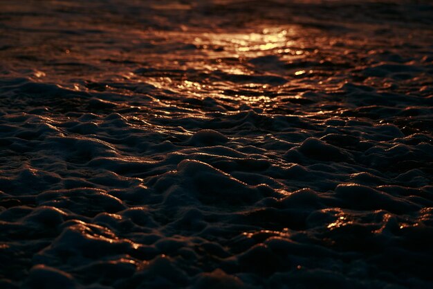 Foto de zon gaat onder op het water en de oceaan kleurt rood.