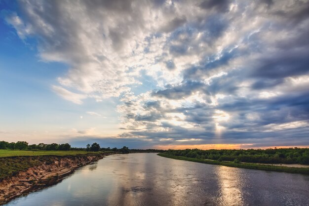 De zon in de wolken boven de rivier