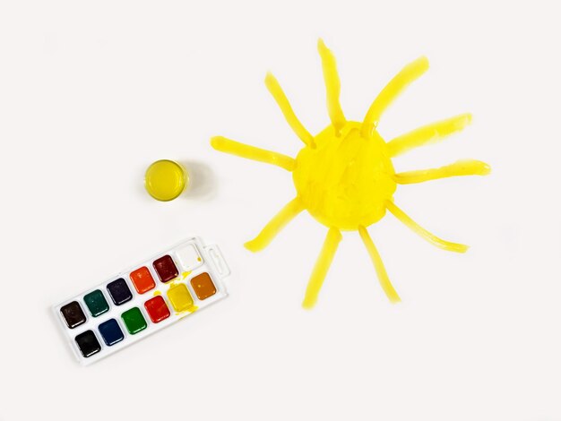 De zon is geel geverfd op een vel wit papier Kindercreativiteit Kindertekening
