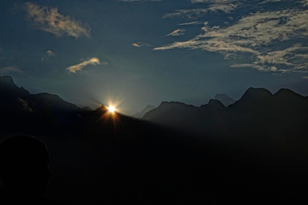 De zon komt op tussen de bergen in Machu Picchu Peru