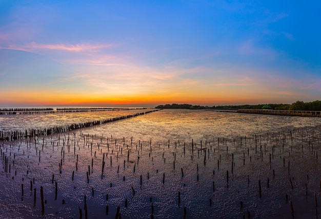 De zonsondergang aan zee door het eb dat de wetlands 's avonds zichtbaar zijn