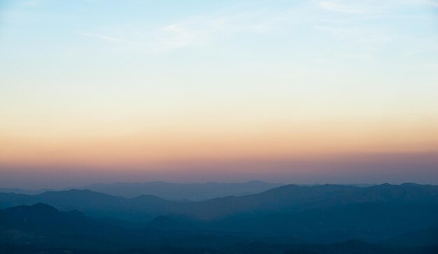 De zonsondergang van het bergminimalisme over het achtergrondpanorama van het bergenlandschap