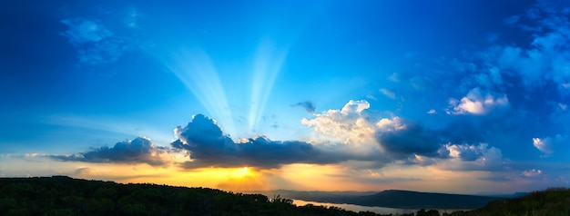 De zonsonderganghemel van het panorama met straallicht in schemeringtijd