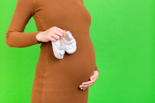 De zwangere schoenen van de vrouwenholding voor een babymeisje