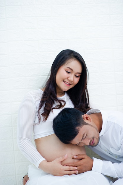 De zwangere vrouw is blij met haar man en bereidt zich voor om naar het kind te kijken dat op het punt staat te bevallen.