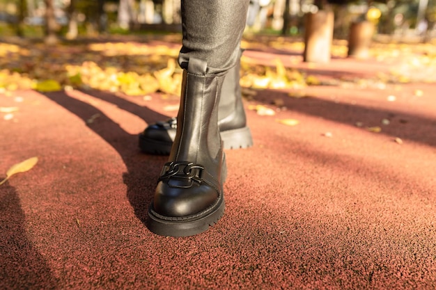 De zwarte laars van een vrouw wordt getoond in een park.