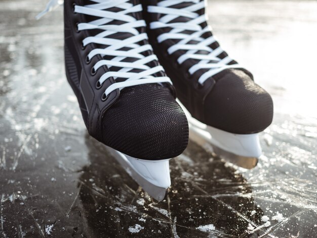 De zwarte schaatsen sluiten omhoog op ijs