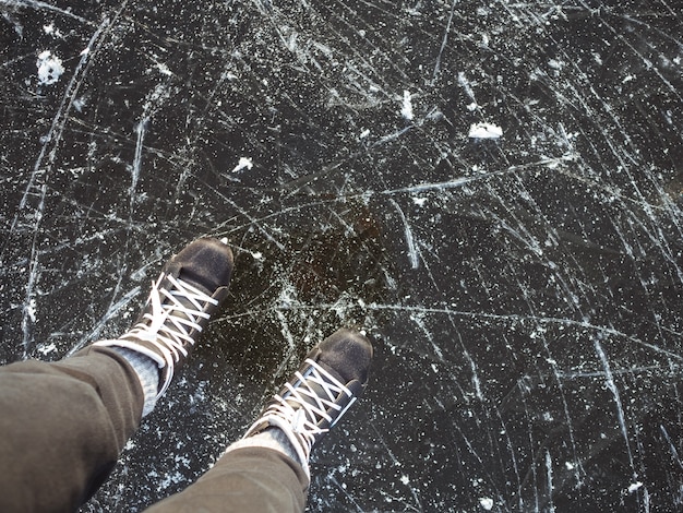 De zwarte schaatsen sluiten omhoog op ijs