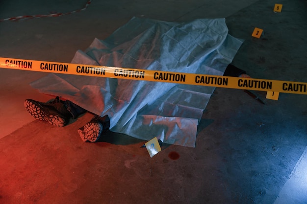 Photo dead body of a man is on the ground covered in white cloth conception of murder homicide