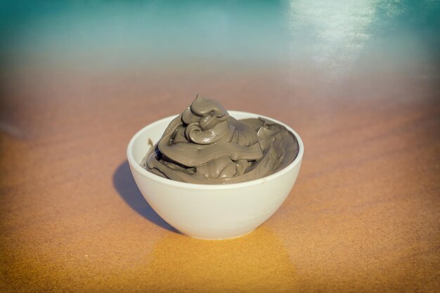 Dead Sea mud for spa treatments in a cup on the beach