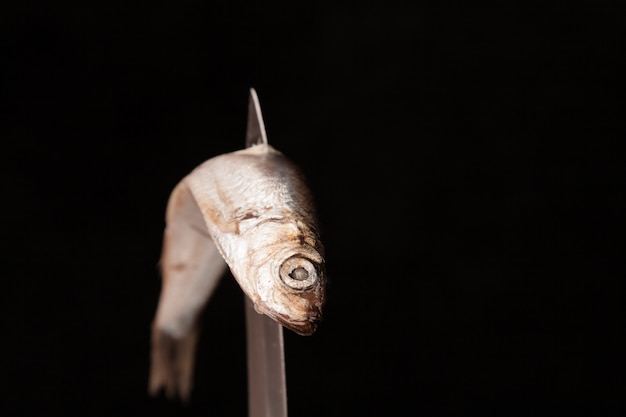 写真 ナイフでゆがんだ死んだ小さな魚