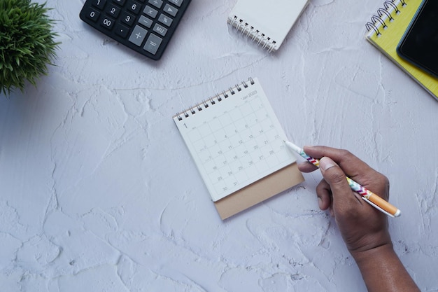 Deadline-concept met handmarkeringsdatum op het bovenaanzicht van de kalender