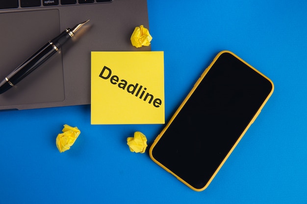 Deadline message on a yellow sticky note