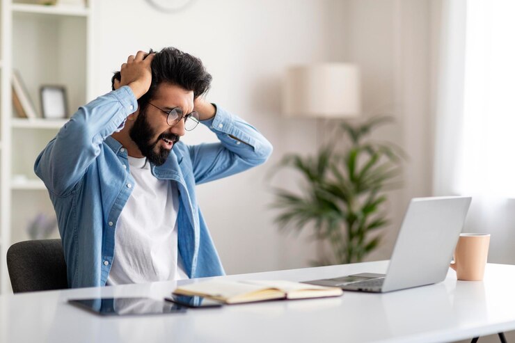 Photo deadline stress shocked indian man looking at laptop screen and touching head