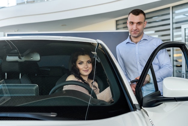 Dealer geeft sleutels van nieuwe auto aan mooie vrouw