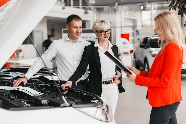 Dealer help for couple choose a car in dealership.