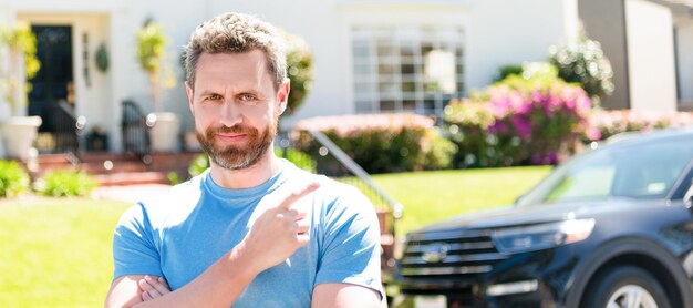 Dealer man staande wijsvinger op auto en nieuw huis Man gezicht portret banner met kopie ruimte