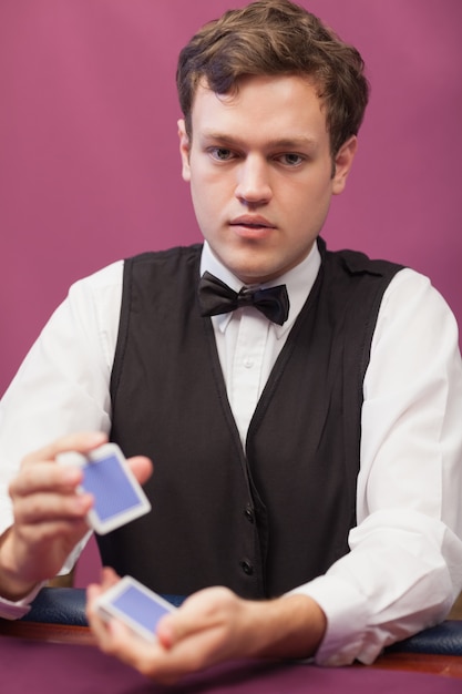 Dealer sitting in a casino while shuffling cards