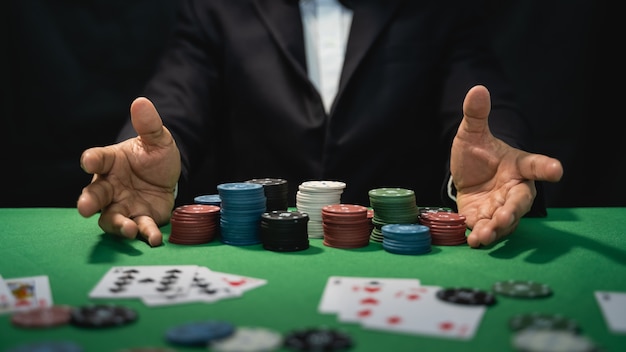 Дилер с покерными картами и фишками в казино