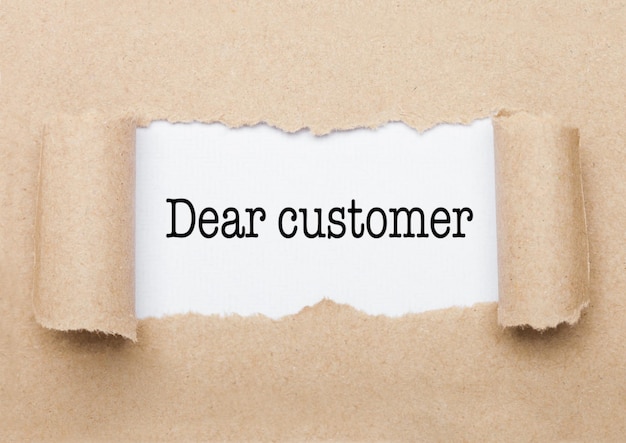 Dear Customer text appearing behind torn brown paper envelope