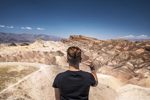 Death valley and a visitor doing okay gesture with his hand